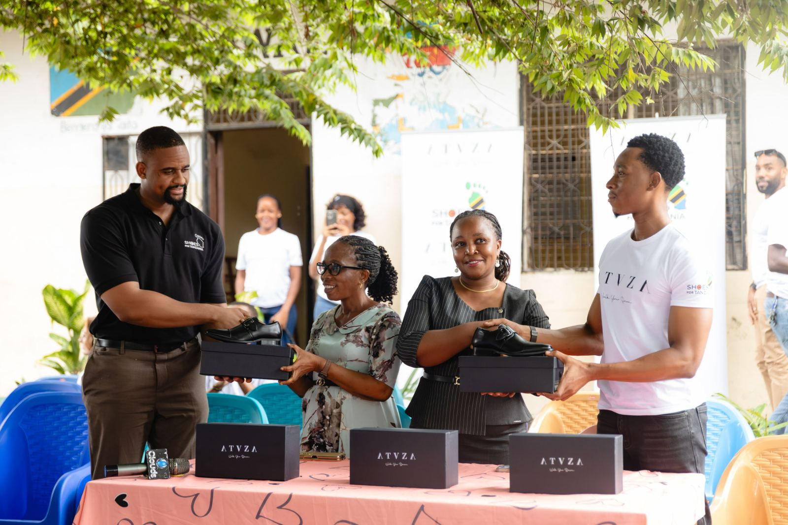 Shoes For Tanzania and ATUZA representatives handing boxes of school shoes to teachers
